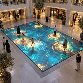 Visitors triggering ripples on a rectangular LED floor in a shopping mall atrium